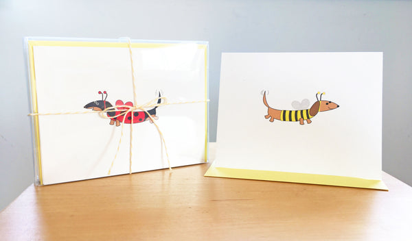 Dachshund assorted note cards with stationery box tied with yellow ribbon, examples are black and tan dachshund dressed as ladybug and brown dachshund dressed as bee