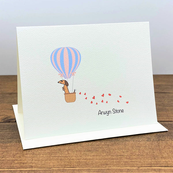 Personalized note card featuring dachshund in hot air balloon with hearts trailing behind