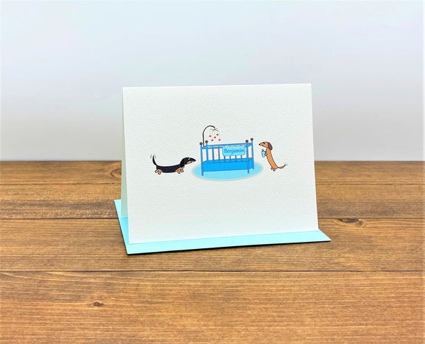 Two dachshunds with baby crib holding bottle, personalized baby note cards.