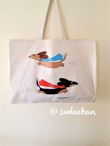 Screen printed large canvas tote with two super dachshunds flying with red and blue capes.